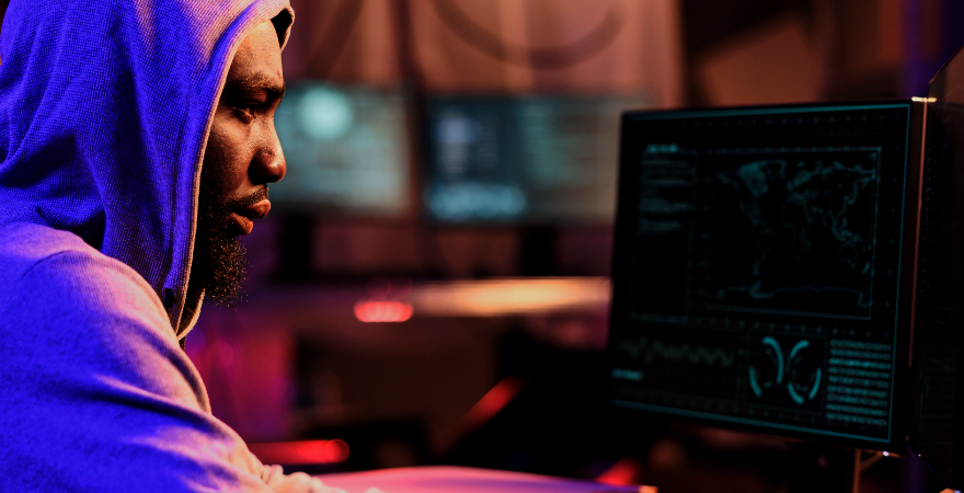 Cyber criminal looking at computer screen