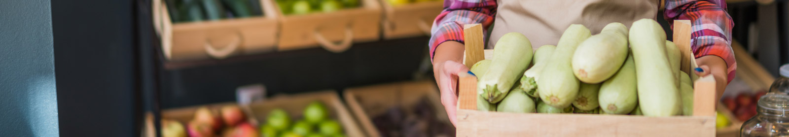 Closeup of woman holding a basket of fruit at supermarket