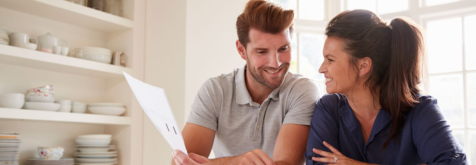 Two people going over finances in kitchen